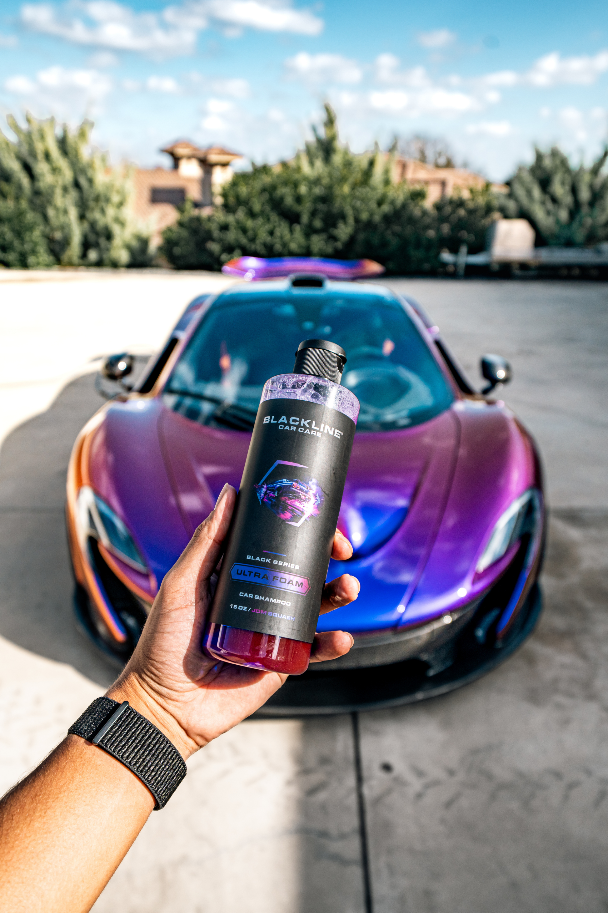 Blackline Ultra Foam car shampoo bottle held in front of a purple car on Tampa Home & Garden Store