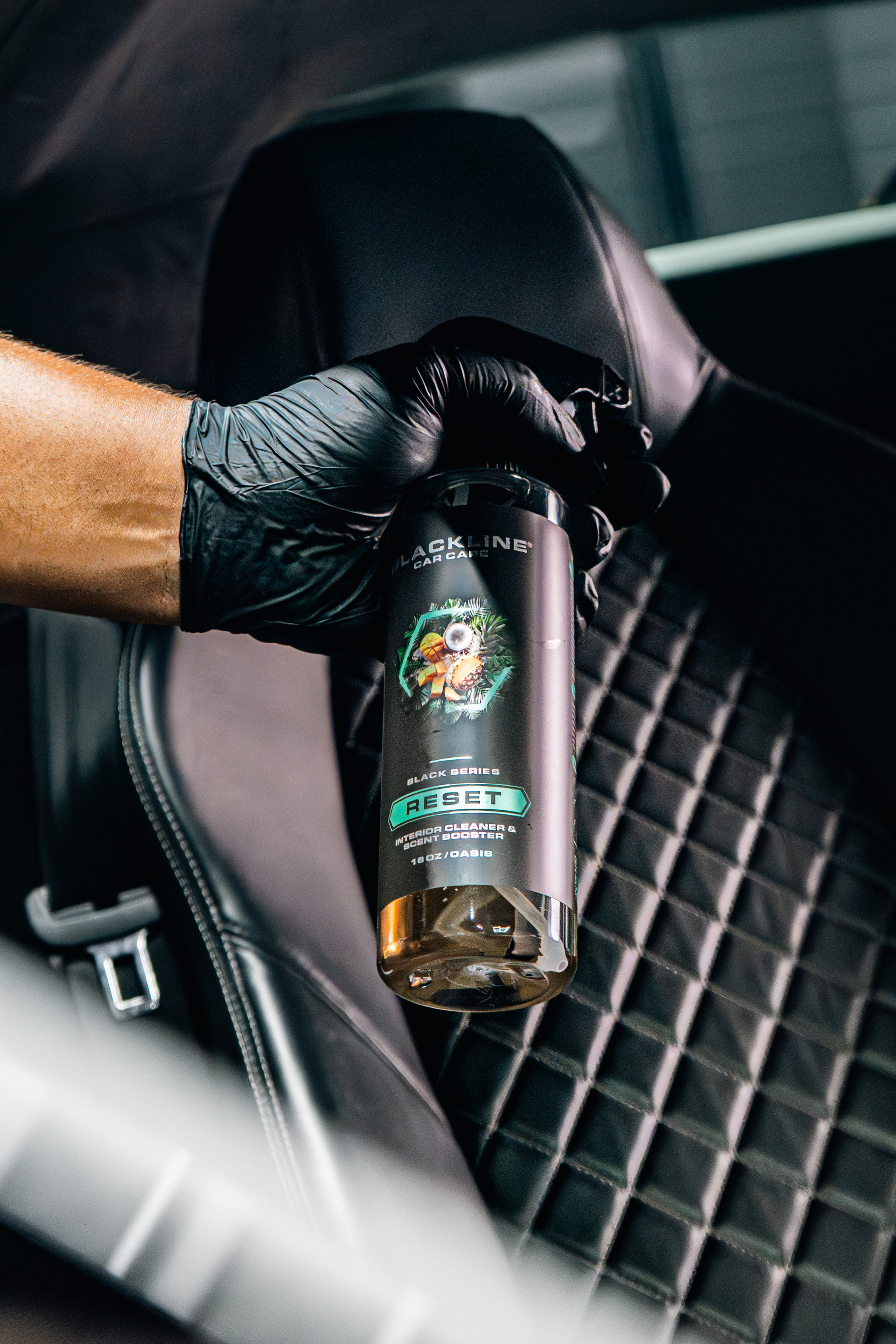 BLACKLINE RESET interior cleaner & scent booster bottle held by gloved hand inside a car on Tampa Home & Garden Store