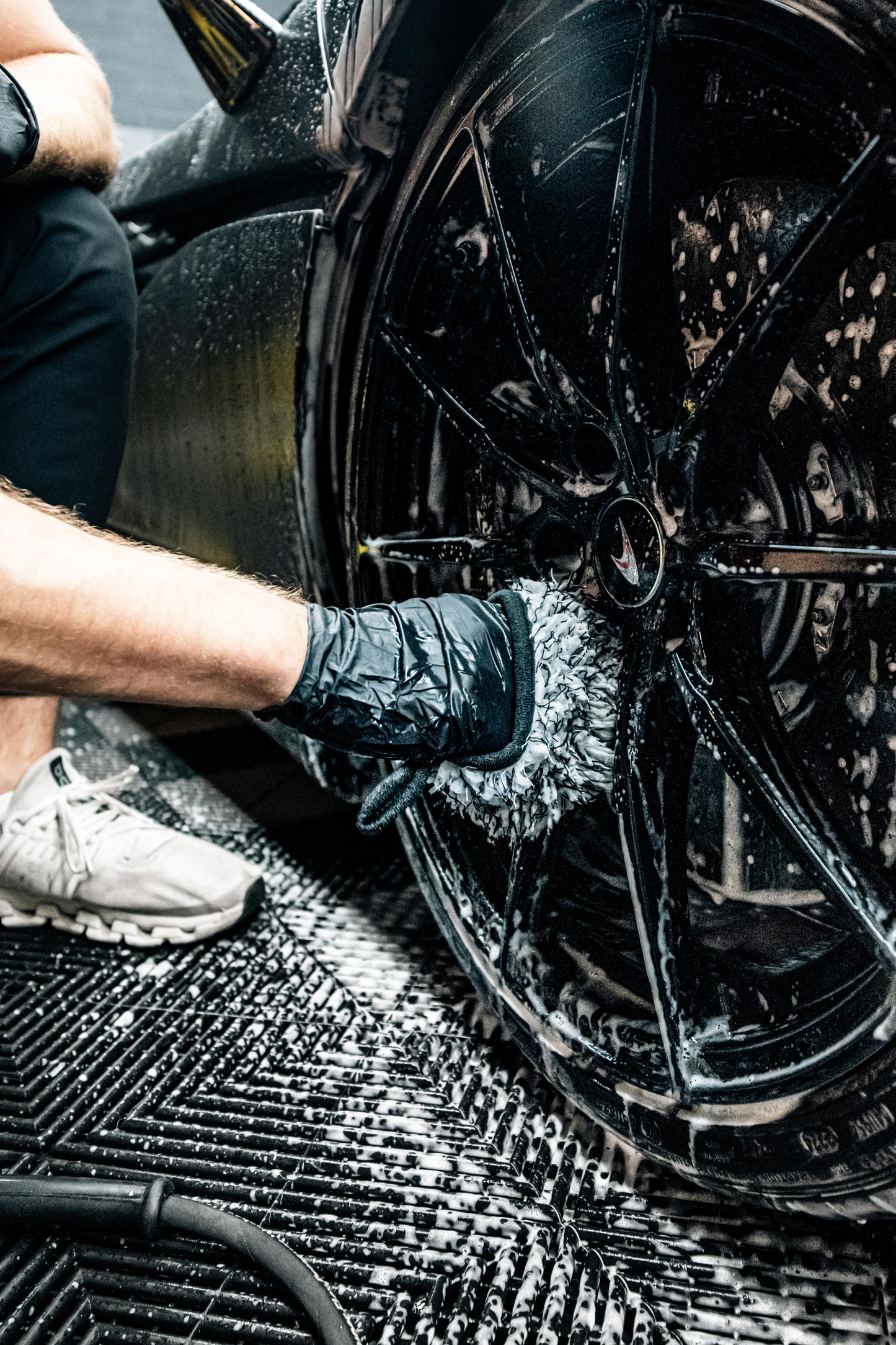 Blackline Car Care microfiber wheel mitt used on a soapy black car wheel during cleaning on Tampa Home & Garden Store