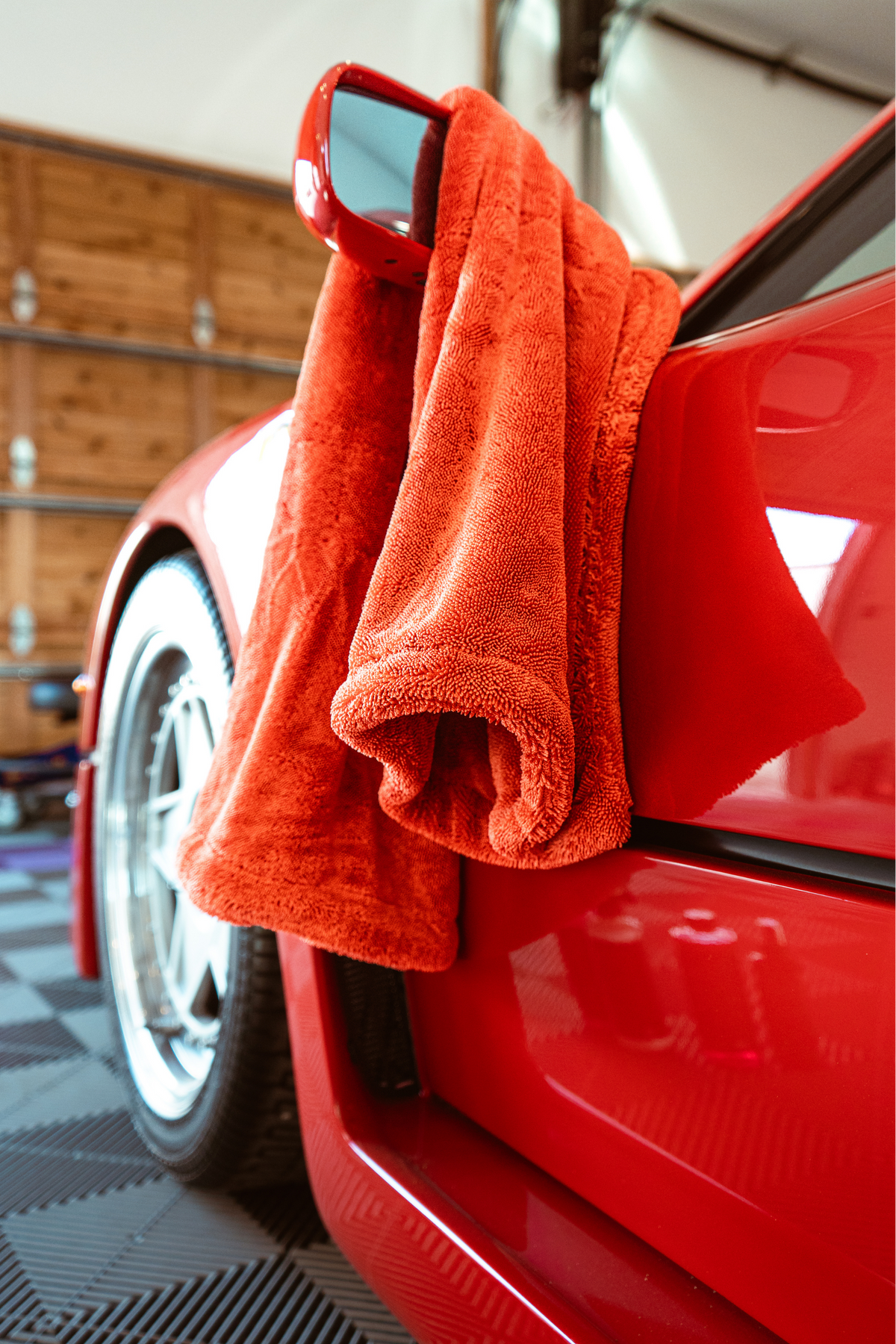 BLACKLINE® Twisted-Loop Drying Towel, orange-red plush microfiber draped over a red car on Tampa Home & Garden Store