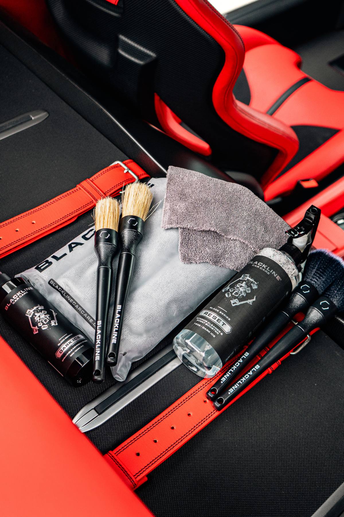 BLACKLINE RESET interior cleaner & scent booster bottle with brushes in red car interior on Tampa Home & Garden Store