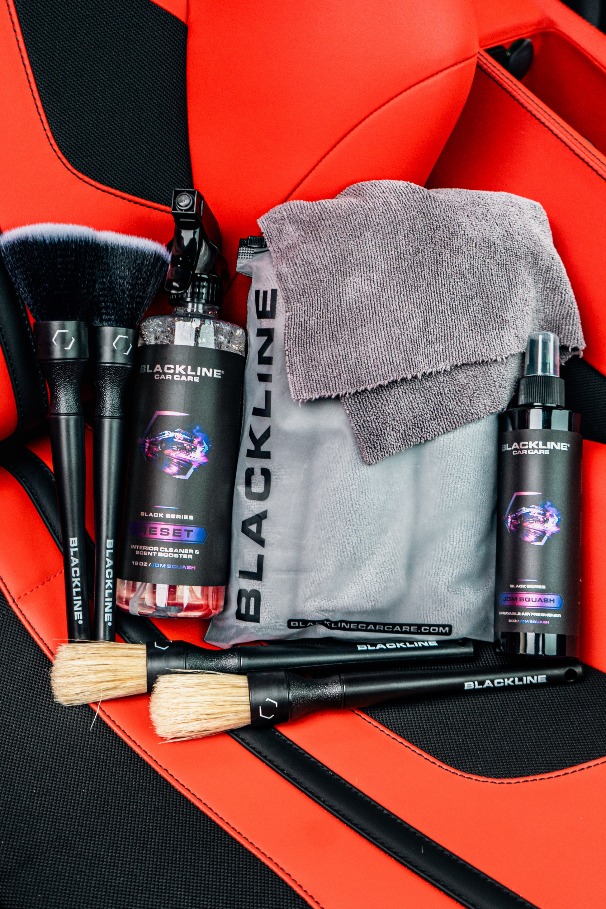 BLACKLINE RESET INTERIOR CLEANER & SCENT BOOSTER bottles with Blackline Car Care on red car seat on Tampa Home & Garden Store