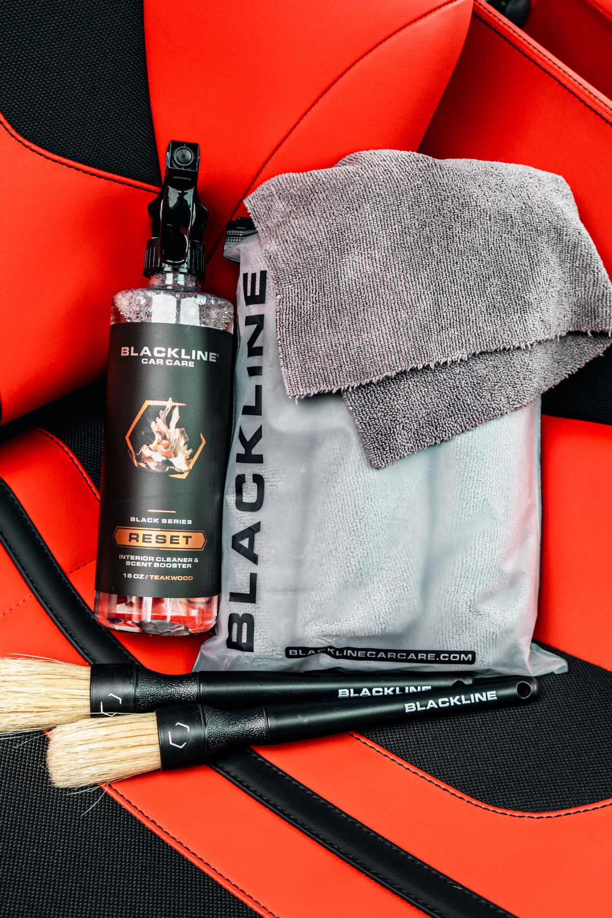 Blackline Reset interior cleaner bottle with spray nozzle beside gray towel and red seat on Tampa Home & Garden Store