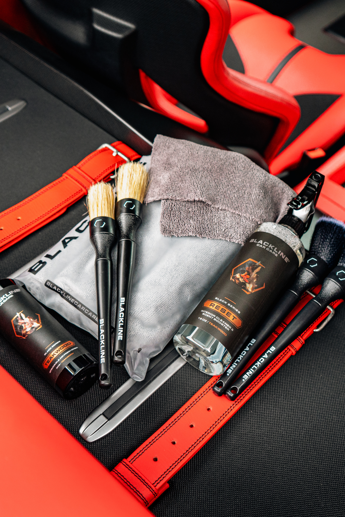 Blackline Reset Interior Cleaner & Scent Booster with spray bottle, brushes, cloths in red car on Tampa Home & Garden Store
