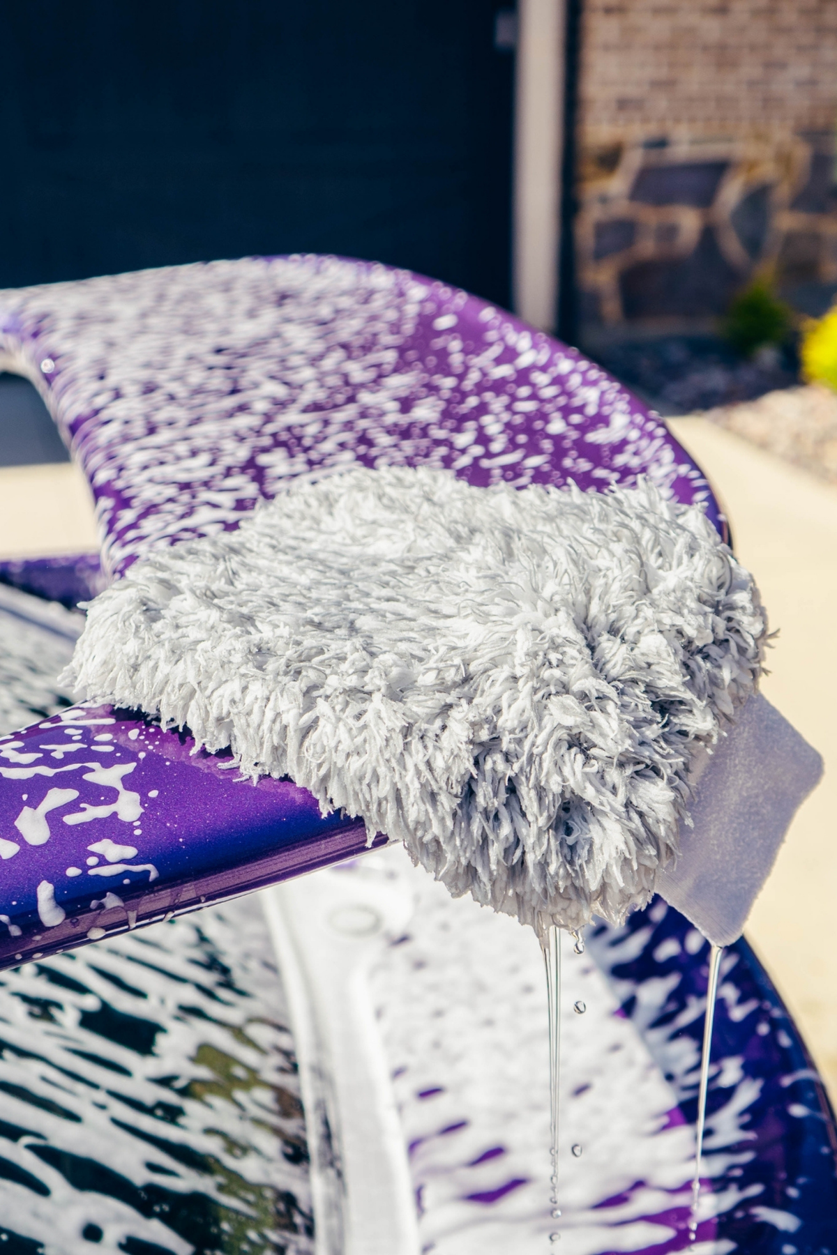 BLACKLINE® MICROFIBER WASH MITT gray microfiber mitt on a purple surface with soap suds on Tampa Home & Garden Store