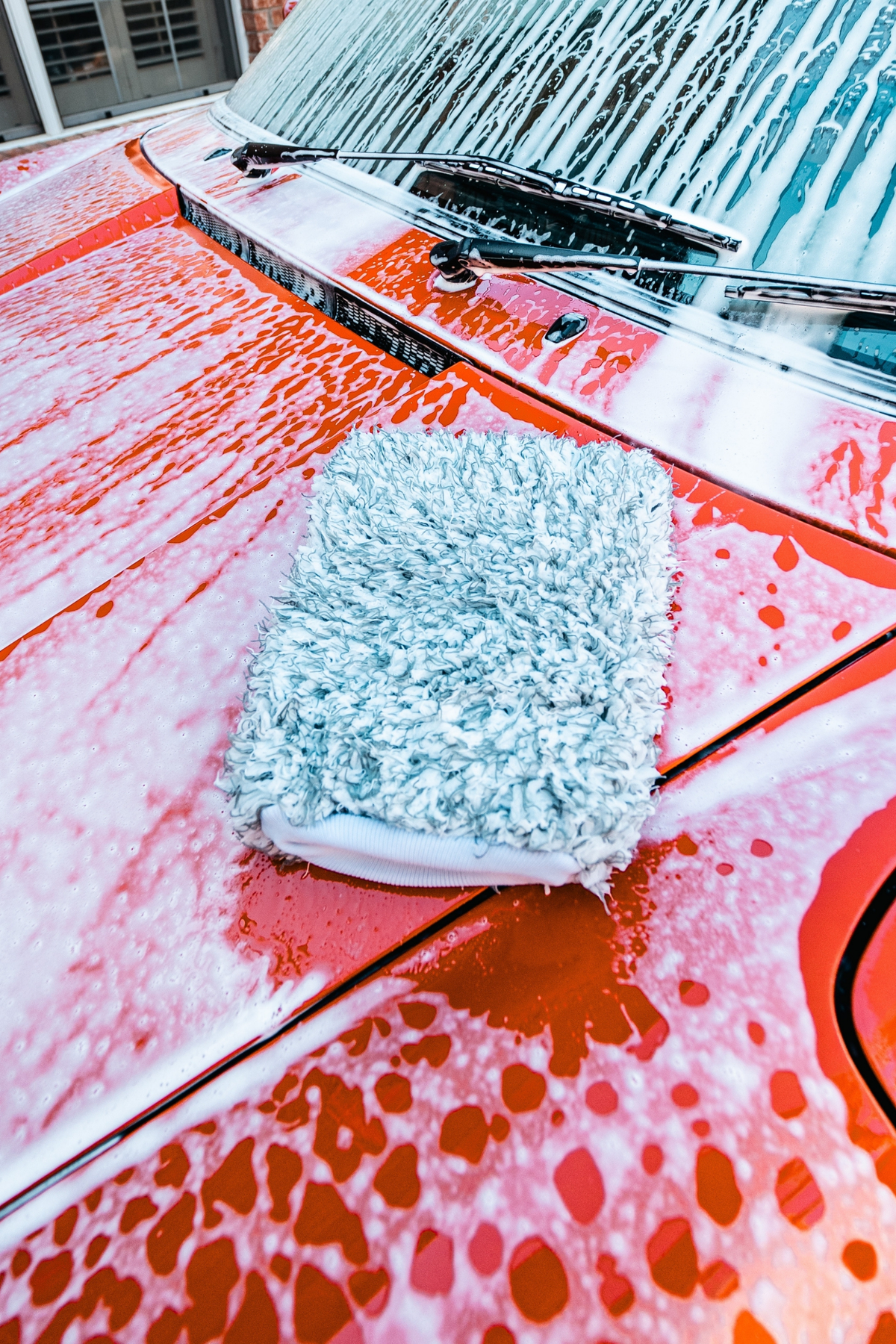 BLACKLINE Microfiber Wash Mitt, gray, for vehicle cleaning on orange car hood with soap suds on Tampa Home & Garden Store