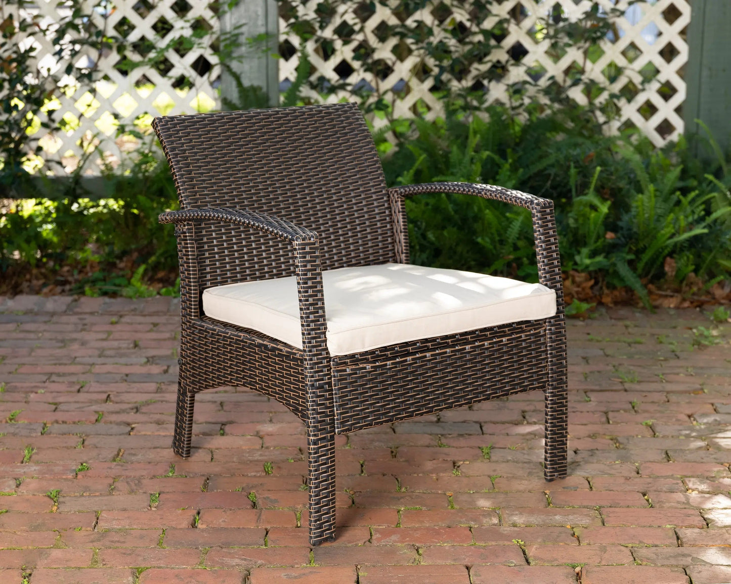 Bondi Wicker Outdoor Armchair in dark brown wicker with cream cushion on brick patio on Tampa Home & Garden Store