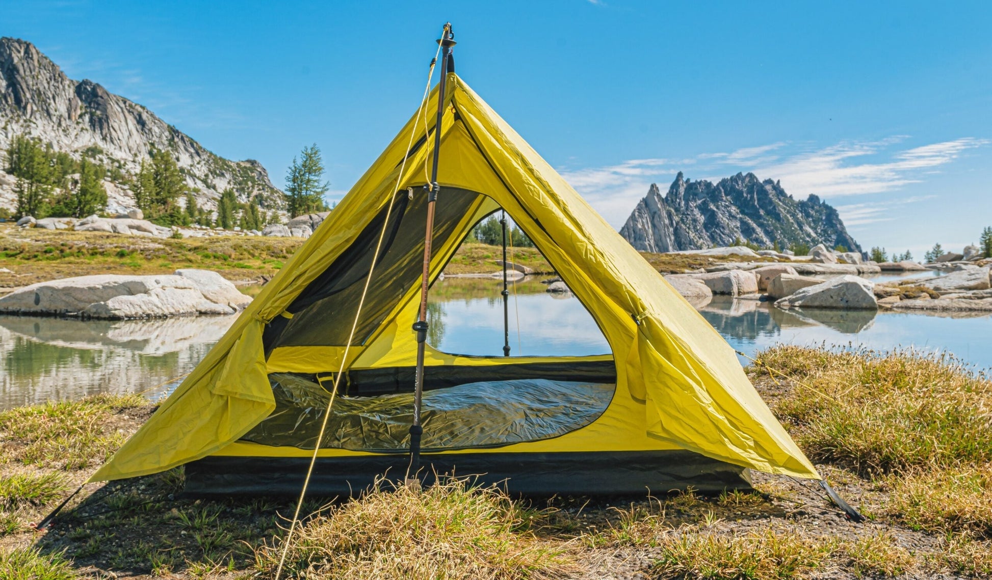 Trekker Palace 2-Person Backpacking Tent in bright yellow pitched by a lake with mountains on Tampa Home & Garden Store