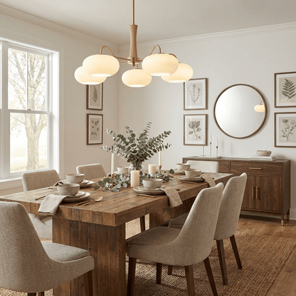Persimmon glass chandelier by Moktan Sabai with brass arms over a rustic wood dining table on Tampa Home & Garden Store