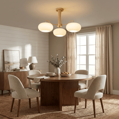 Persimmon glass chandelier with brass arms over a round wood dining table on Tampa Home & Garden Store