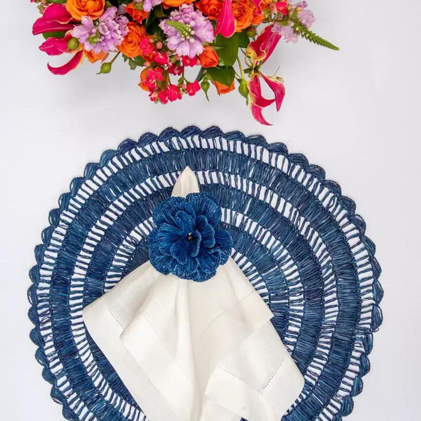 Buriti straw placemats round navy blue woven with white napkin and blue flower accent on Tampa Home & Garden Store