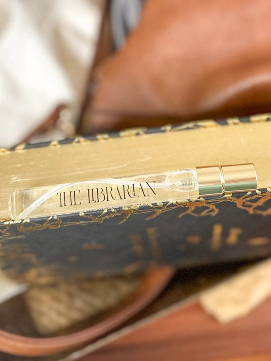 The Librarian Travel Perfume bottle with a gold cap on a decorative gold surface on Tampa Home & Garden Store