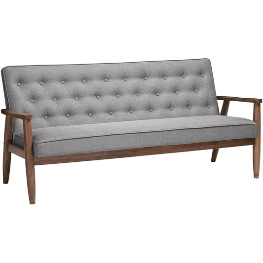Sofá tapizado moderno gris con botones y estructura de madera con acabado en nogal oscuro