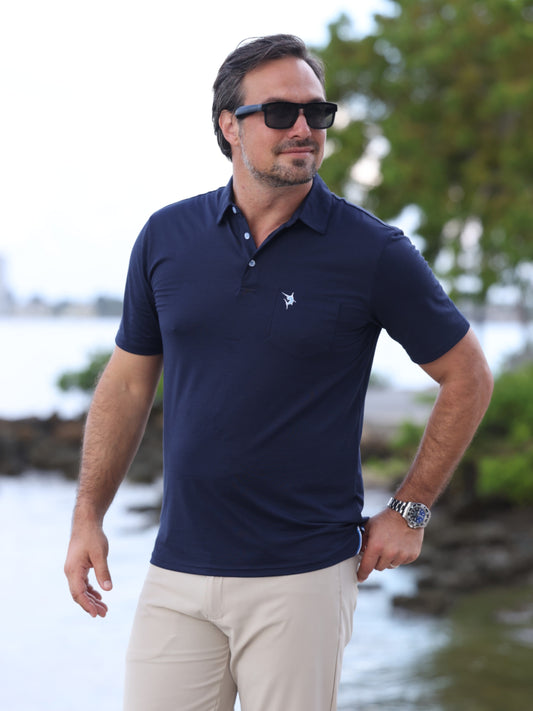 Charleston Polo navy polo shirt by White Water Life with chest logo, worn by man outdoors on Tampa Home & Garden Store