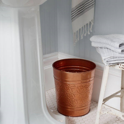 Copper finish metal trash can with embossed geometric pattern in bathroom beside towels on Tampa Home & Garden Store