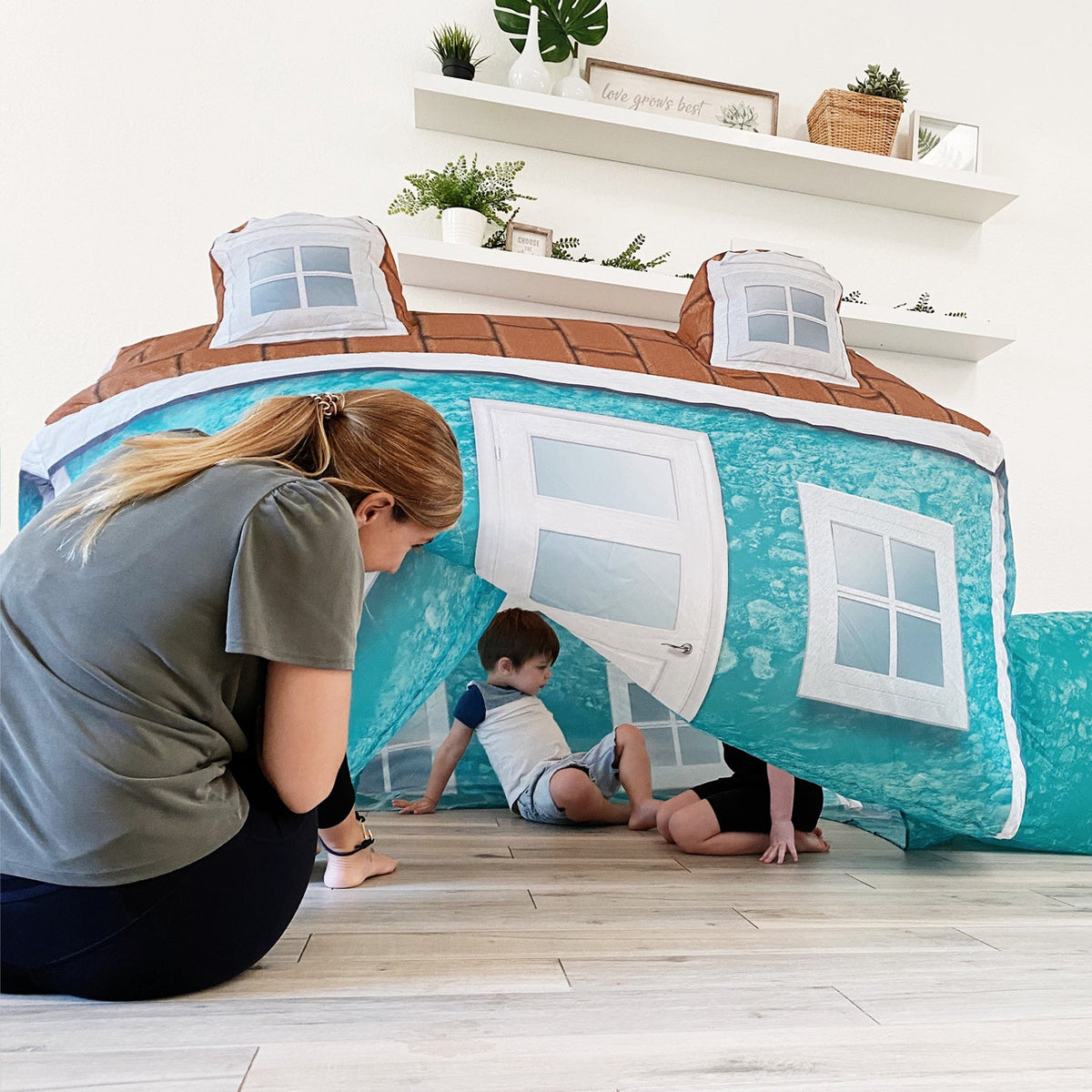 AirFort Cabin inflatable play fort turquoise exterior with white window panels and door on Tampa Home & Garden Store