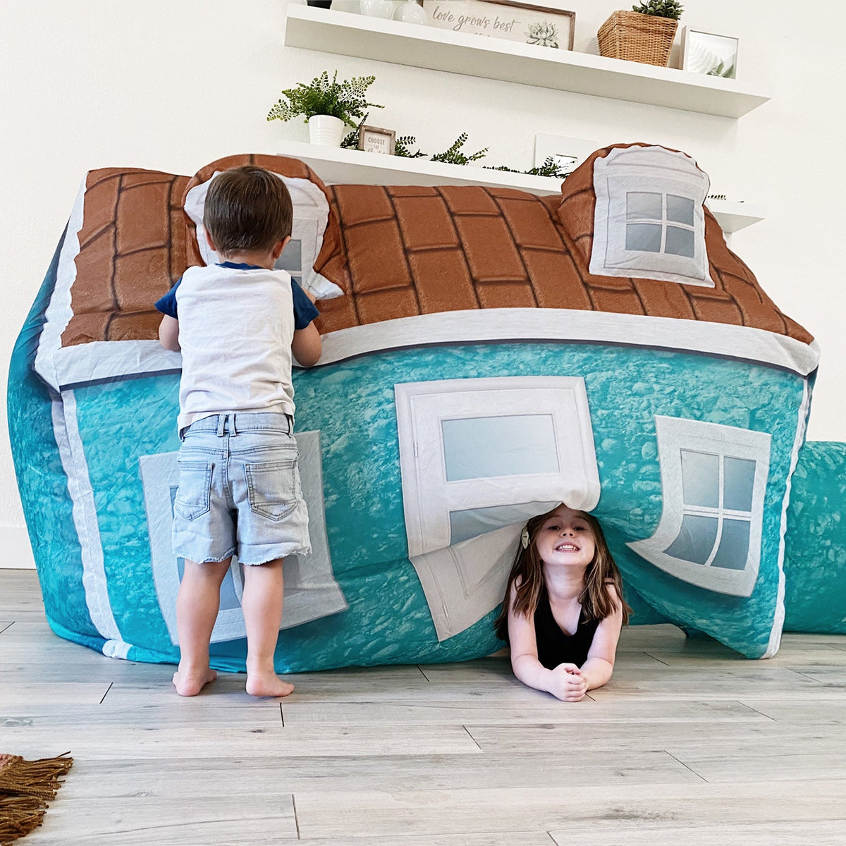 AirFort Cabin Inflatable Kids Play Fort teal walls with brick-pattern top and windows, two kids on Tampa Home & Garden Store