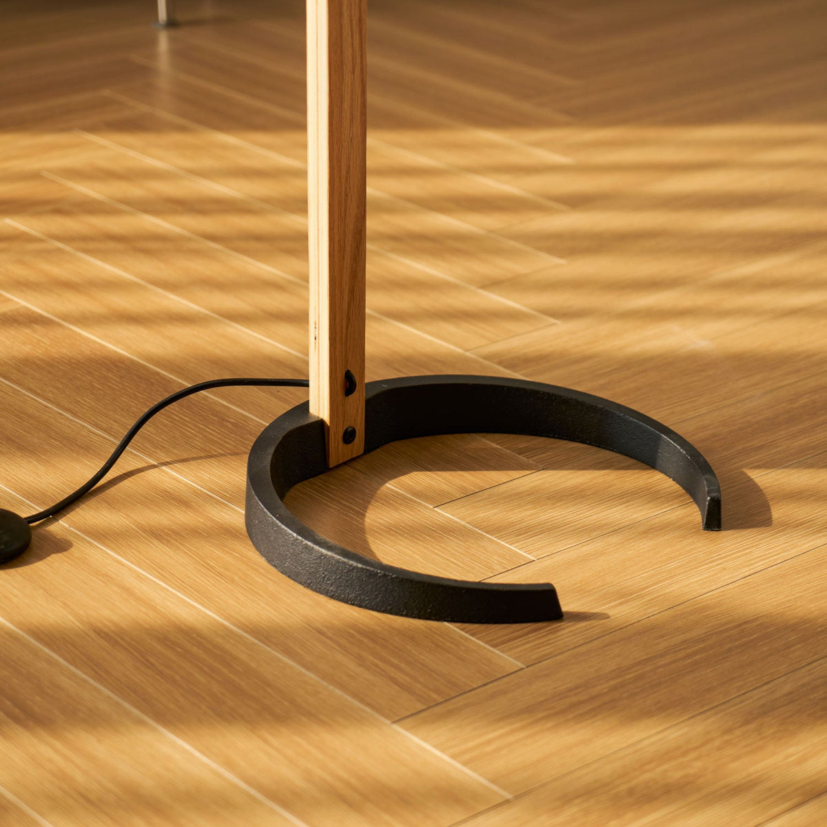Arbora Arc floor lamp with beech wood stem and black base, plug-in cord visible on floor on Tampa Home & Garden Store