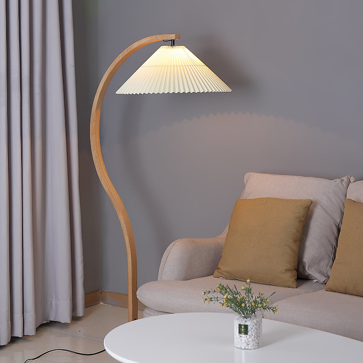 Arbora Arc floor lamp in natural beech wood with a pleated cream shade beside a beige sofa on Tampa Home & Garden Store