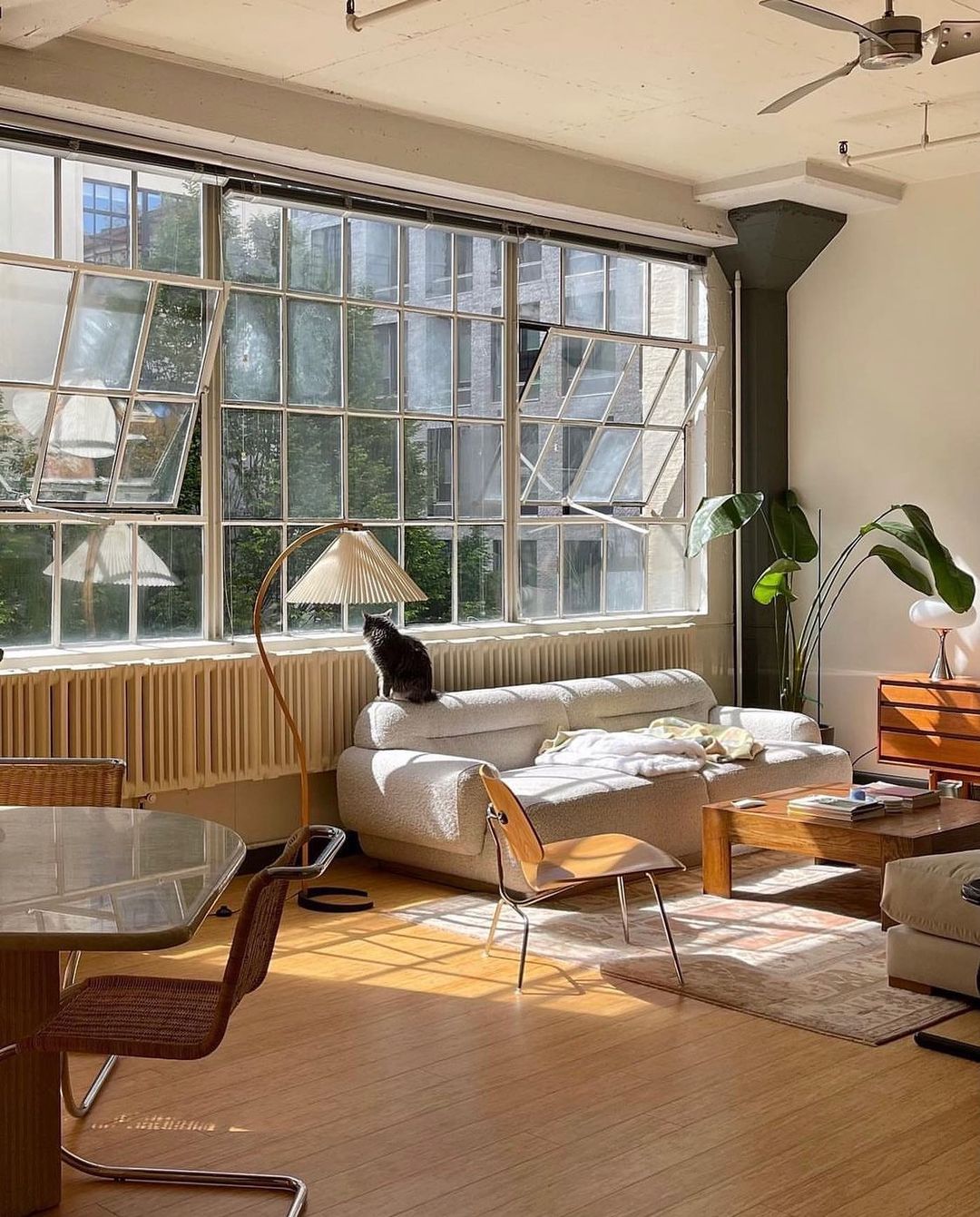 Arbora Arc Floor Lamp with beech wood arm and pleated shade by Moktan Sabai in living room on Tampa Home & Garden Store