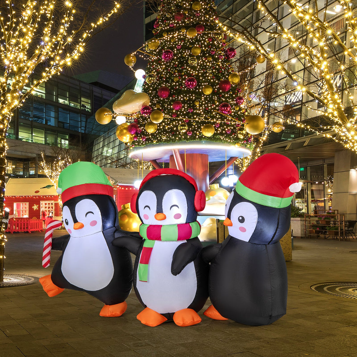 DirectDeals inflatable penguin family (3) with red/green hats, in front of a lit LED tree on Tampa Home & Garden Store