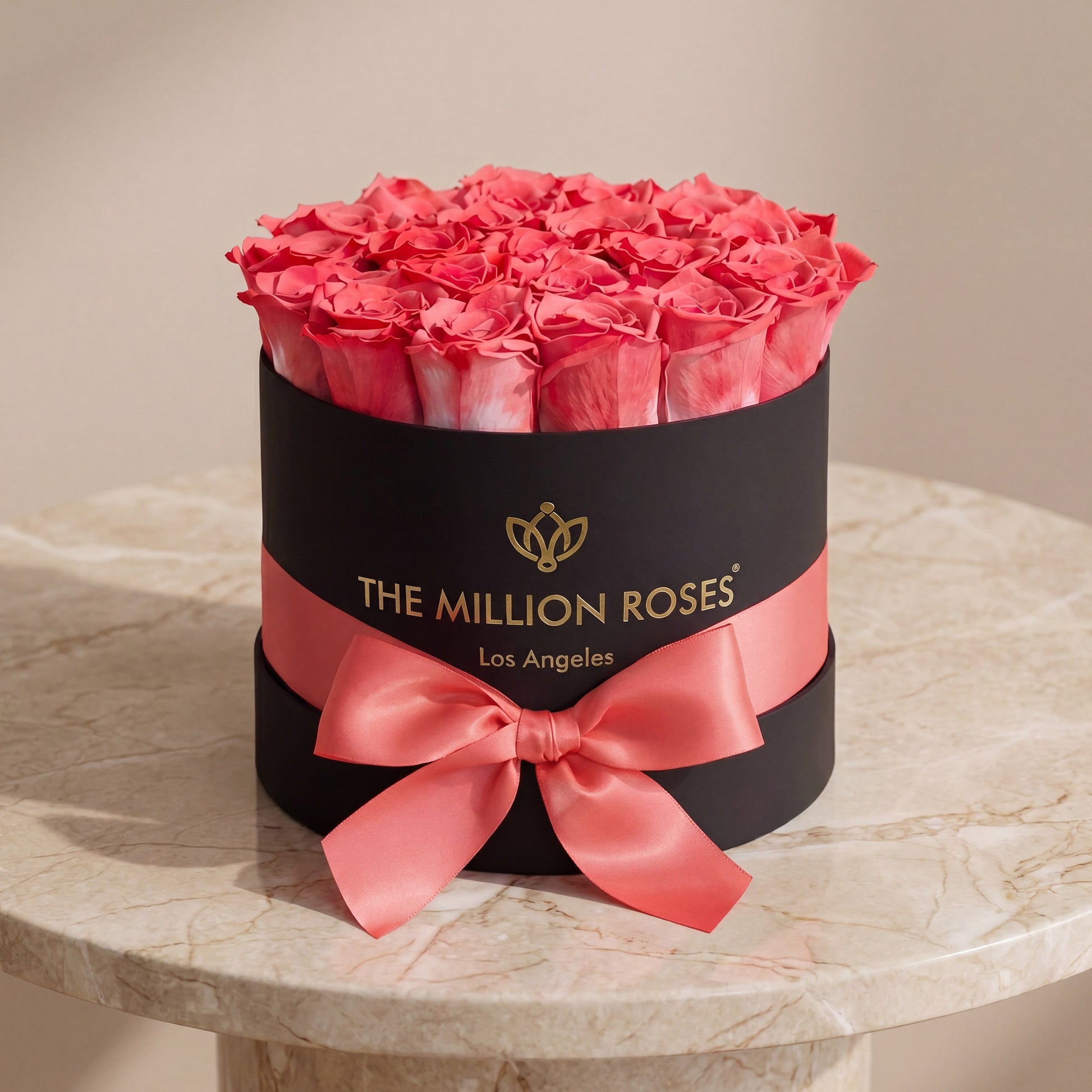 The Million Roses Classic Black Box coral pink roses in a black hatbox with pink ribbon on Tampa Home & Garden Store