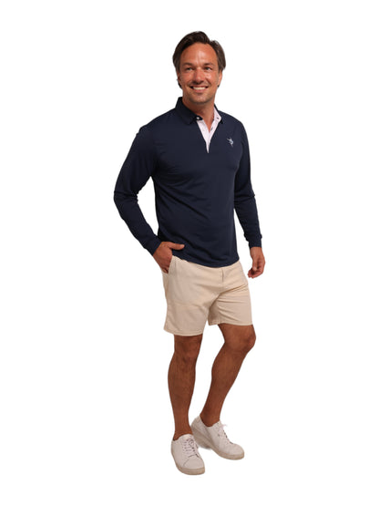 Coast Long Sleeve Polo navy with white placket and small chest logo; man in beige shorts on Tampa Home & Garden Store