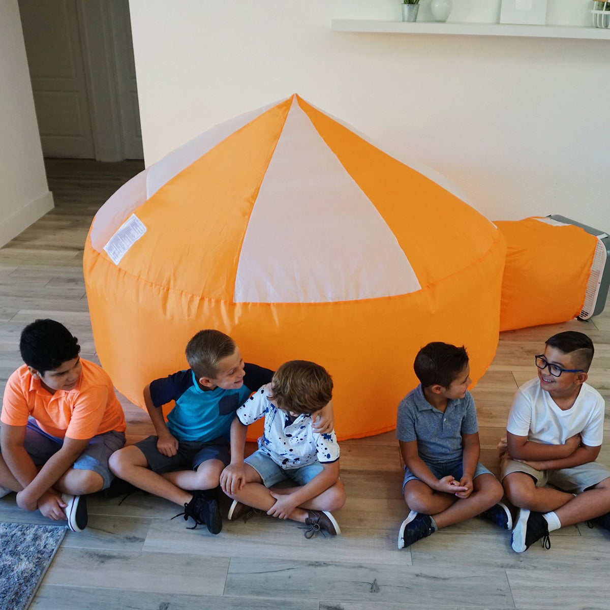 AirFort Creamsicle Orange inflatable play fort dome with blower; kids sit around on Tampa Home & Garden Store