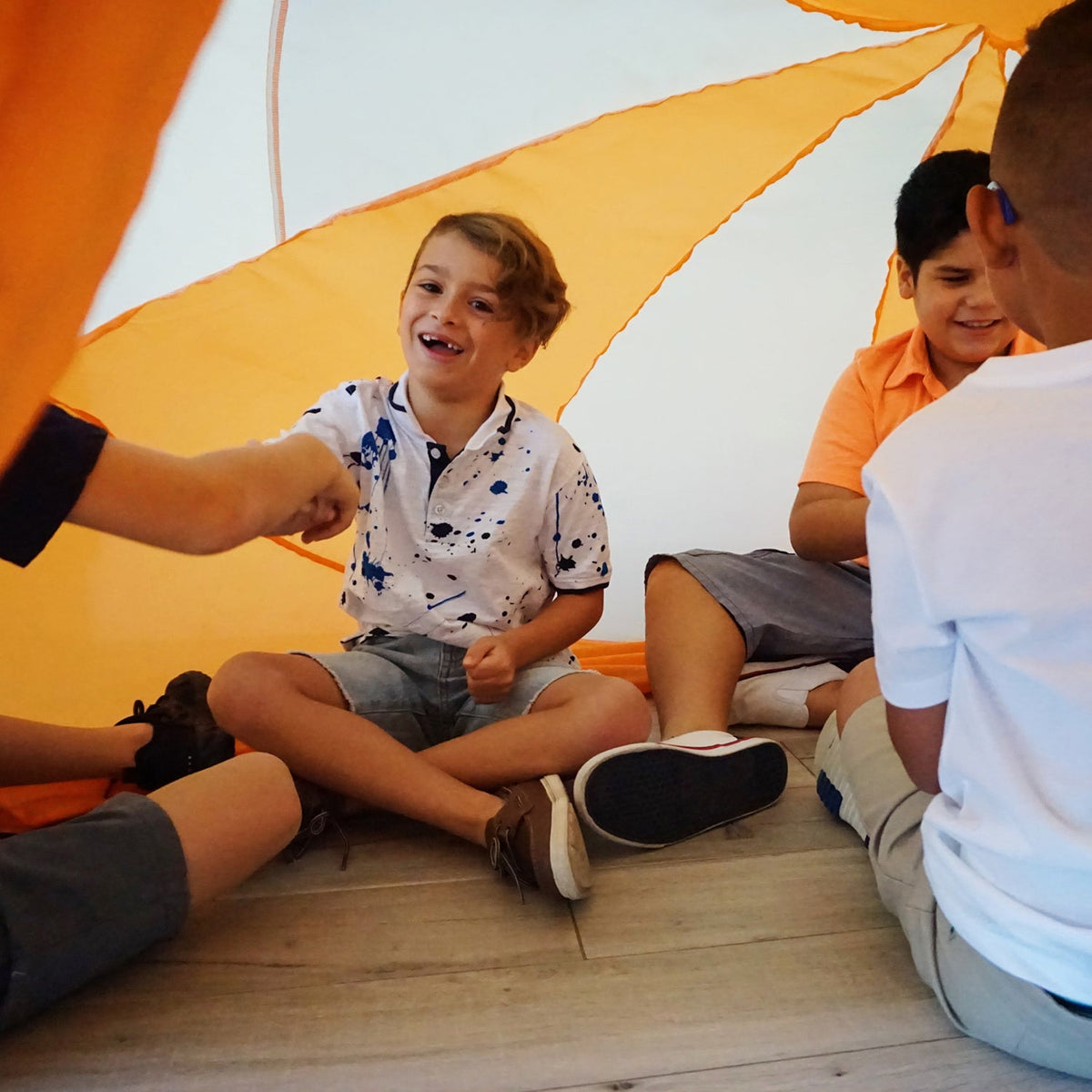 AirFort Creamsicle Orange inflatable play fort with 3 children inside on Tampa Home & Garden Store