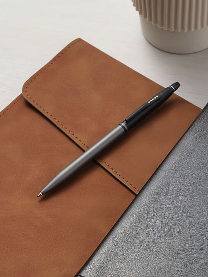 A.T. Cross Click Tuxedo satin metallic gray ballpoint pen with black cap on tan leather notebook on Tampa Home & Garden Store