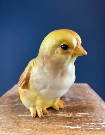 Cute plump yellow baby chick figurine ceramic decor with orange beak on a wood surface on Tampa Home & Garden Store