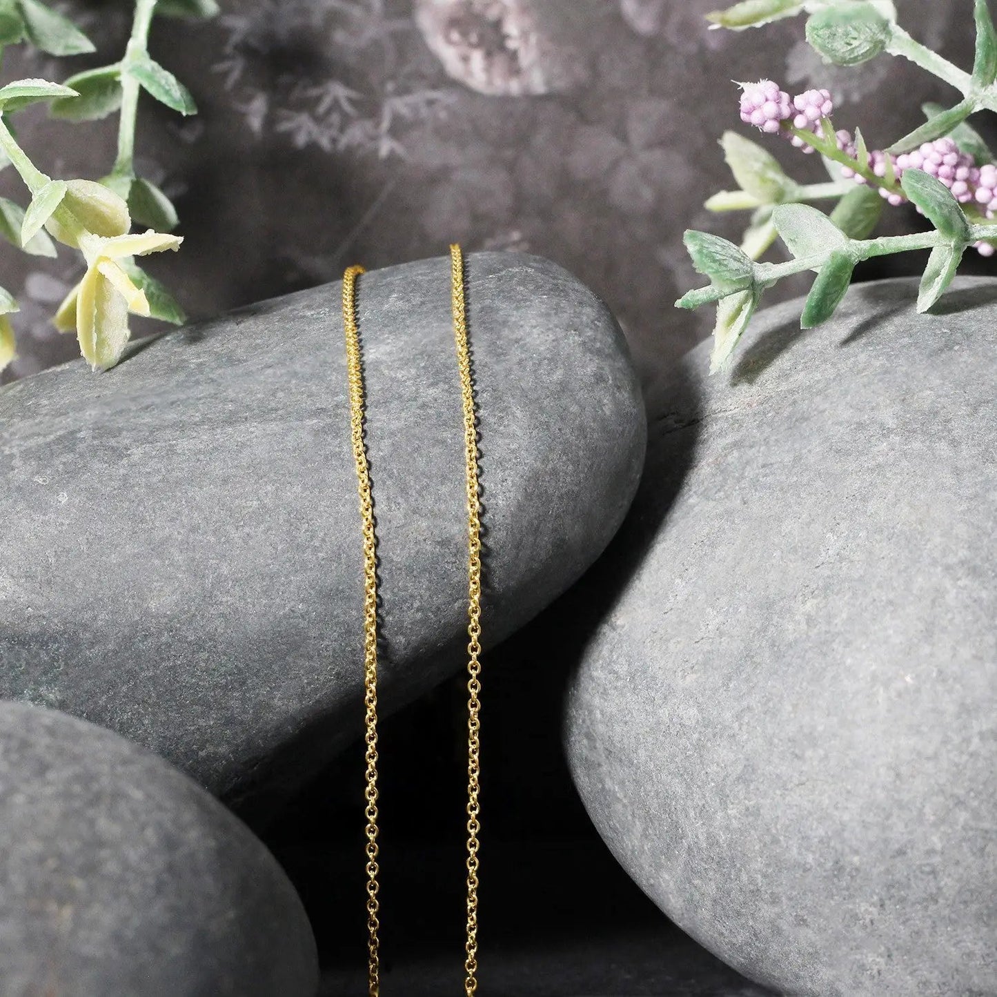 14k yellow gold round cable link chain necklace 1.2mm, two chains draped on gray stones on Tampa Home & Garden Store