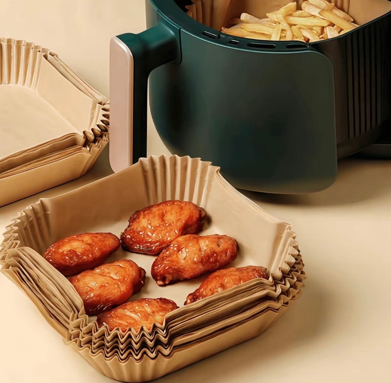 CleanBake Air Fryer Liners lining a tray with six chicken wings beside a green fryer on Tampa Home & Garden Store