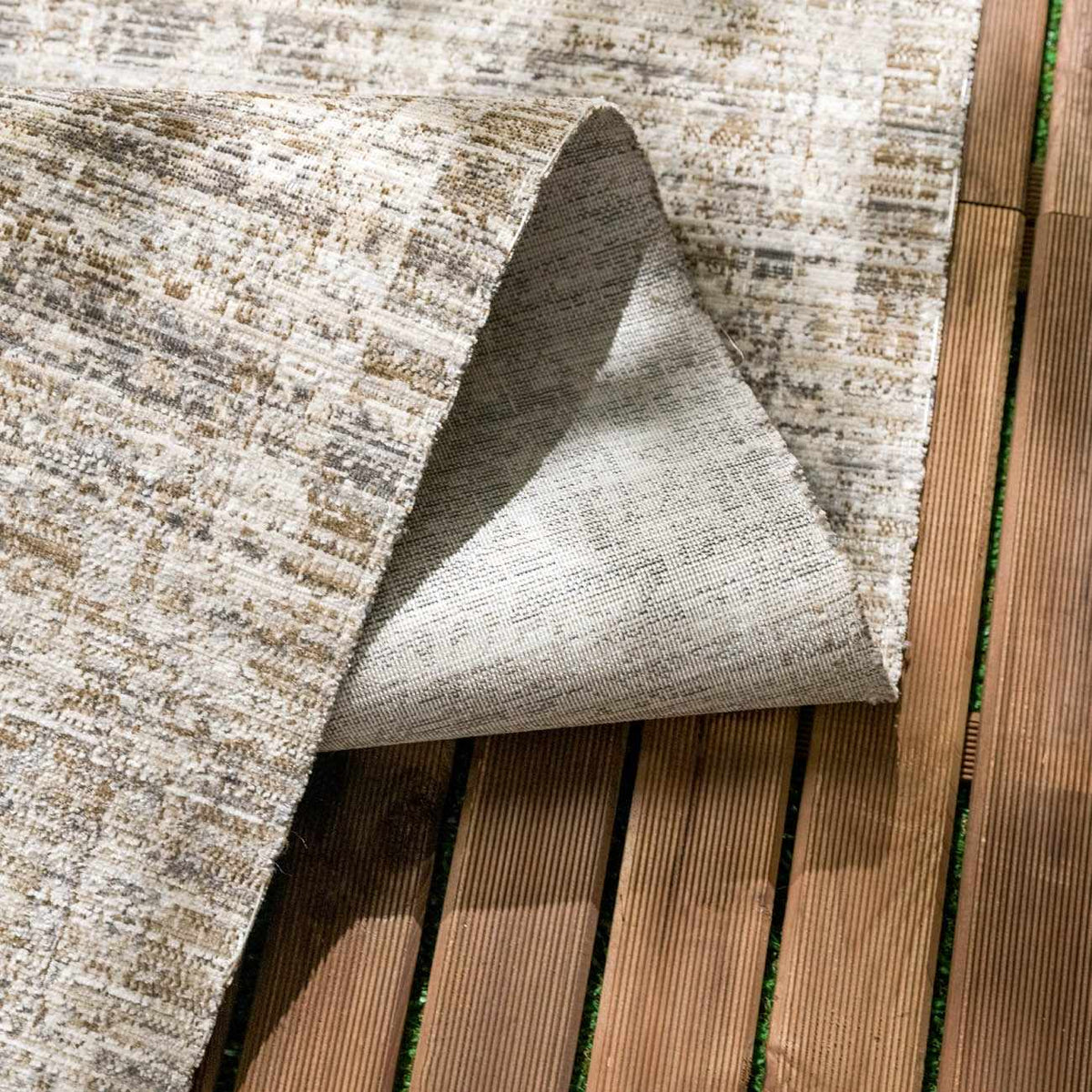 Uzuri washable outdoor area rug by Boutique Rugs in beige/tan pattern on wooden deck on Tampa Home & Garden Store