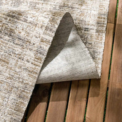 Uzuri washable outdoor area rug by Boutique Rugs in beige/tan pattern on wooden deck on Tampa Home & Garden Store
