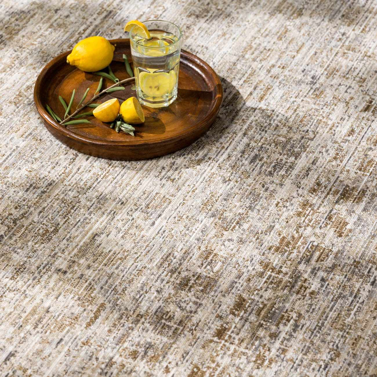 Uzuri washable outdoor area rug beige under a wooden tray with lemons and a glass of water on Tampa Home & Garden Store