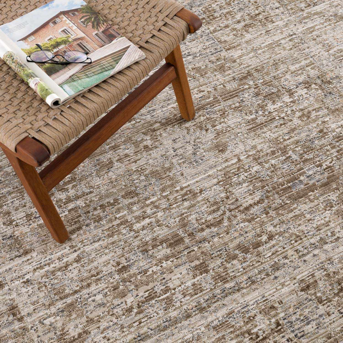 Aistys washable outdoor area rug beige distressed pattern Boutique Rugs on a woven bench on Tampa Home & Garden Store