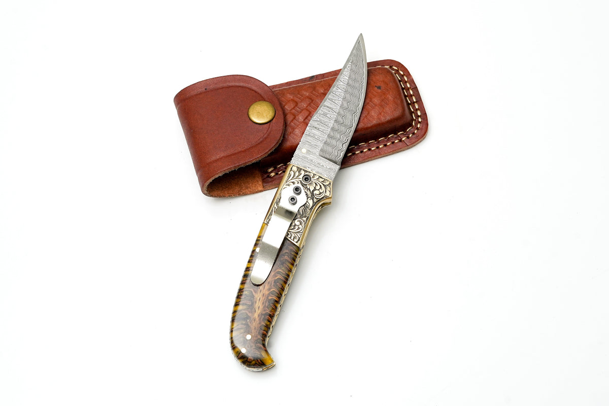 Damascus steel clip point folding knife with eagle bolster and amber pine cone handle on Tampa Home & Garden Store
