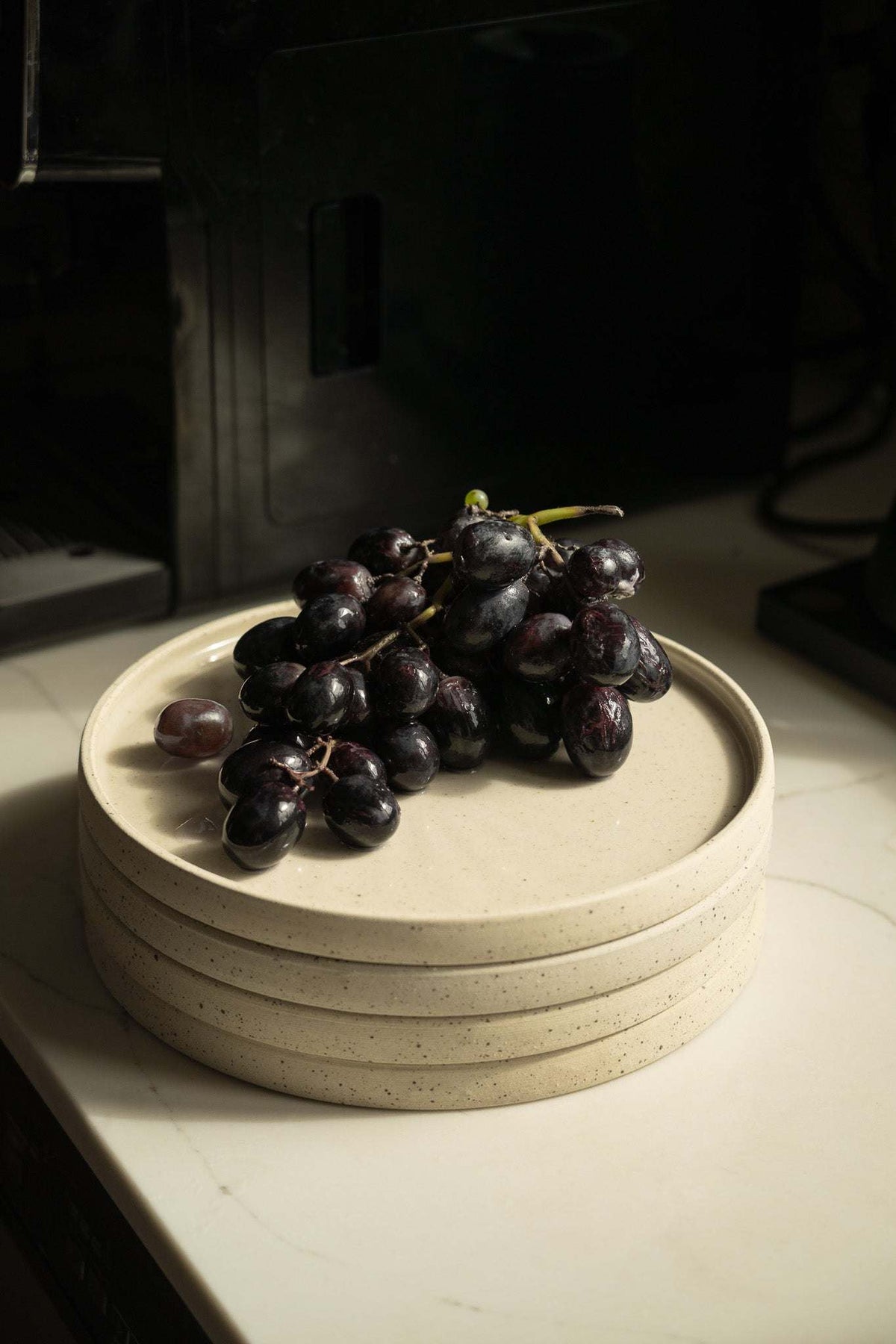 Handmade stoneware plate white with speckles stacked plates with a grape cluster on top on Tampa Home & Garden Store