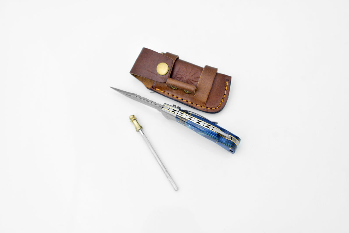 TF-049 Damascus steel bolster knife with belt clip, blue handle beside brown leather sheath on Tampa Home & Garden Store