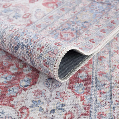 Rust Goma Vintage Area Rug close-up of faded red blue beige pattern with rolled edge on Tampa Home & Garden Store
