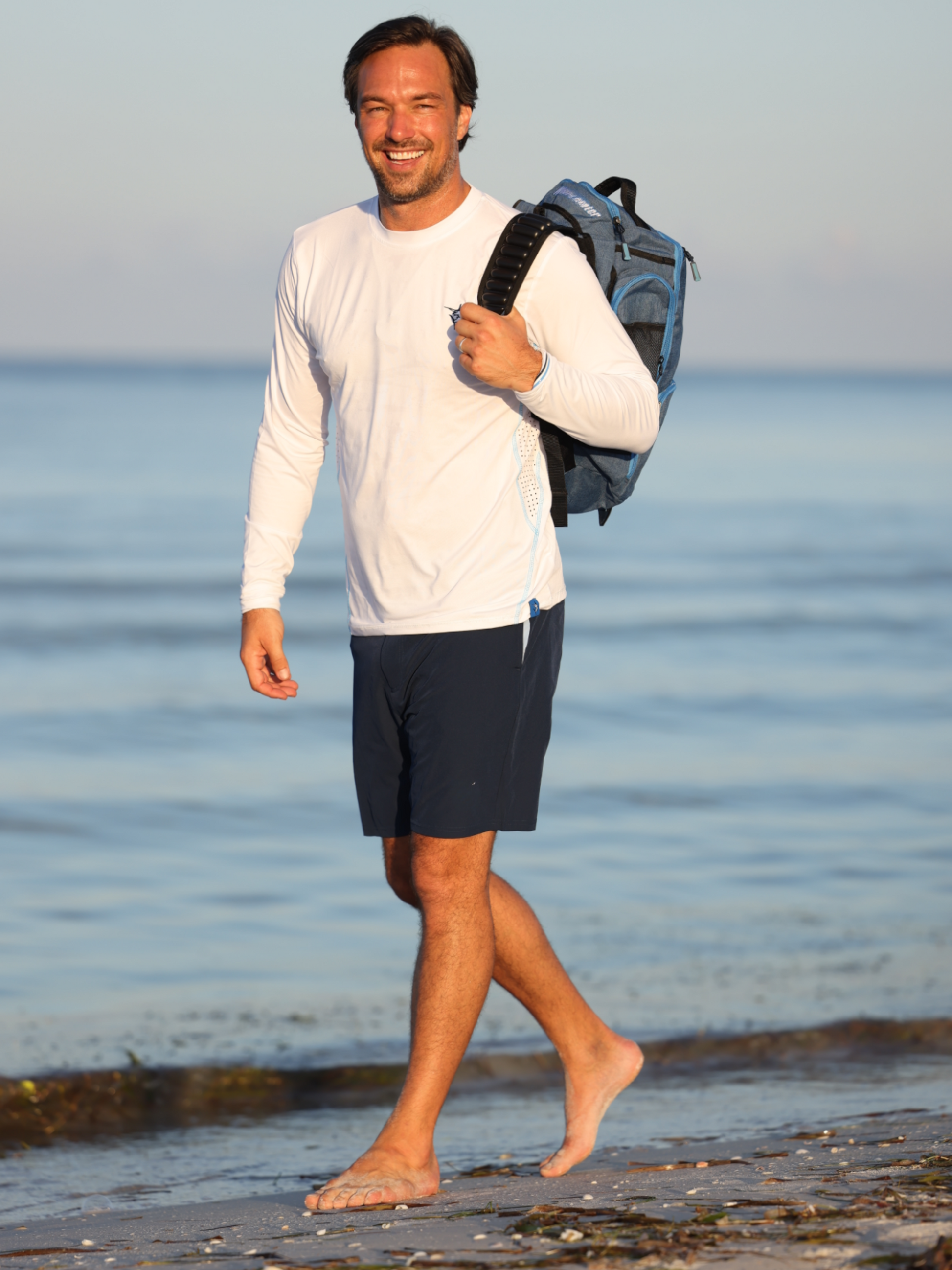 Dockside Performance Long Sleeve white top by White Water Life with backpack at the beach on Tampa Home & Garden Store