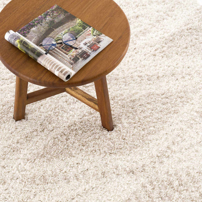 Hauteloom Trunding Plush Rug light beige on beige shag floor beside a round wooden table on Tampa Home & Garden Store