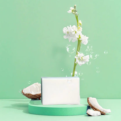 Solid Coconut Soap Bar by Green Llama, white bar on mint-green display with coconut props on Tampa Home & Garden Store