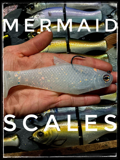Bacca Burrito boot-tail soft swimbait held in hand; translucent glitter body with blue tint on Tampa Home & Garden Store