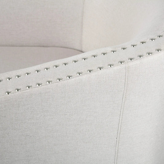 Wheat Fabric Swivel Chair upholstery close-up with silver nailhead trim along seam on Tampa Home & Garden Store
