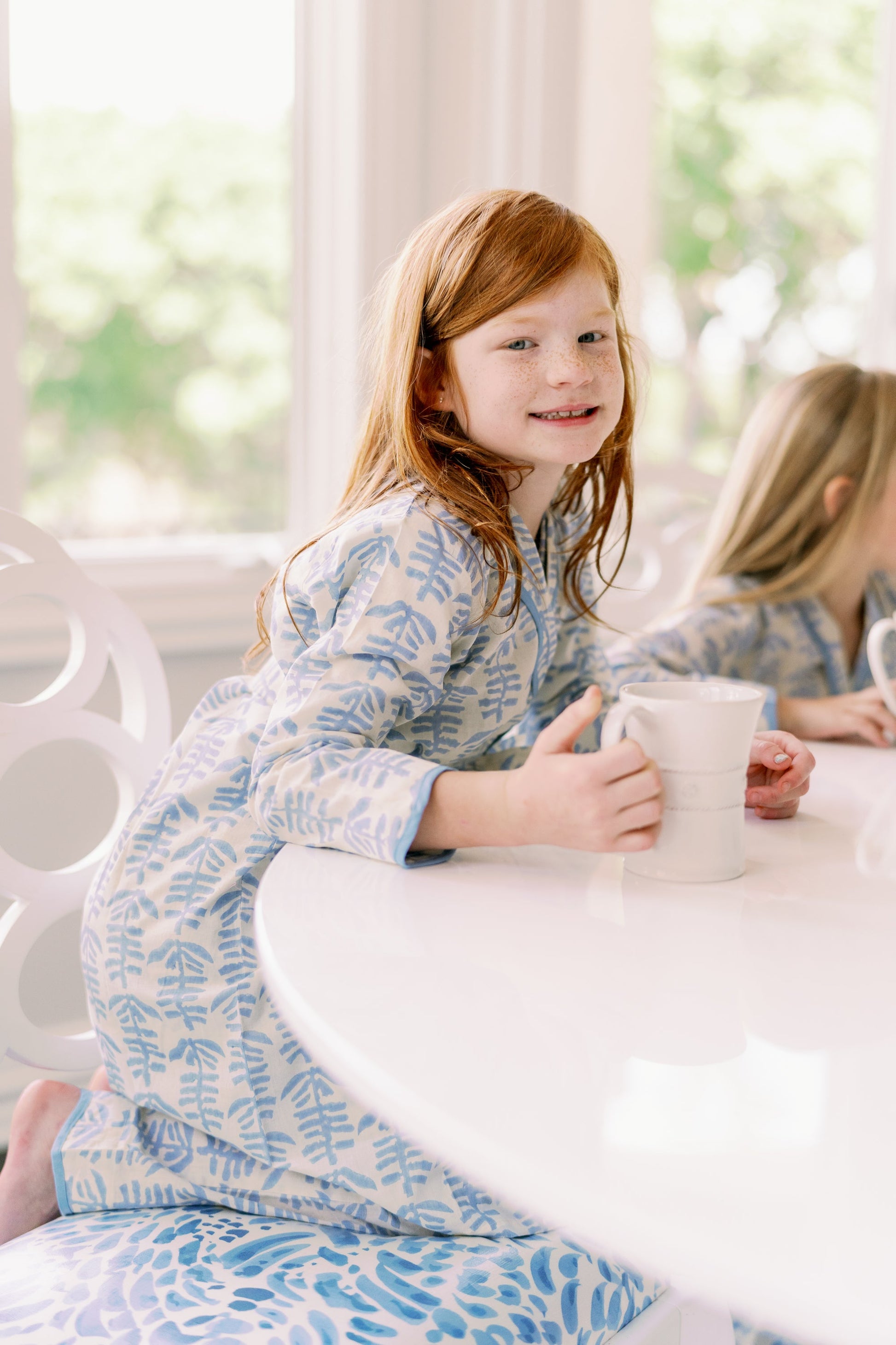 Mini Trellis Pajama blue set with long-sleeve top and pants, red-haired girl at a white table holding a mug on Tampa Home & Garden Store