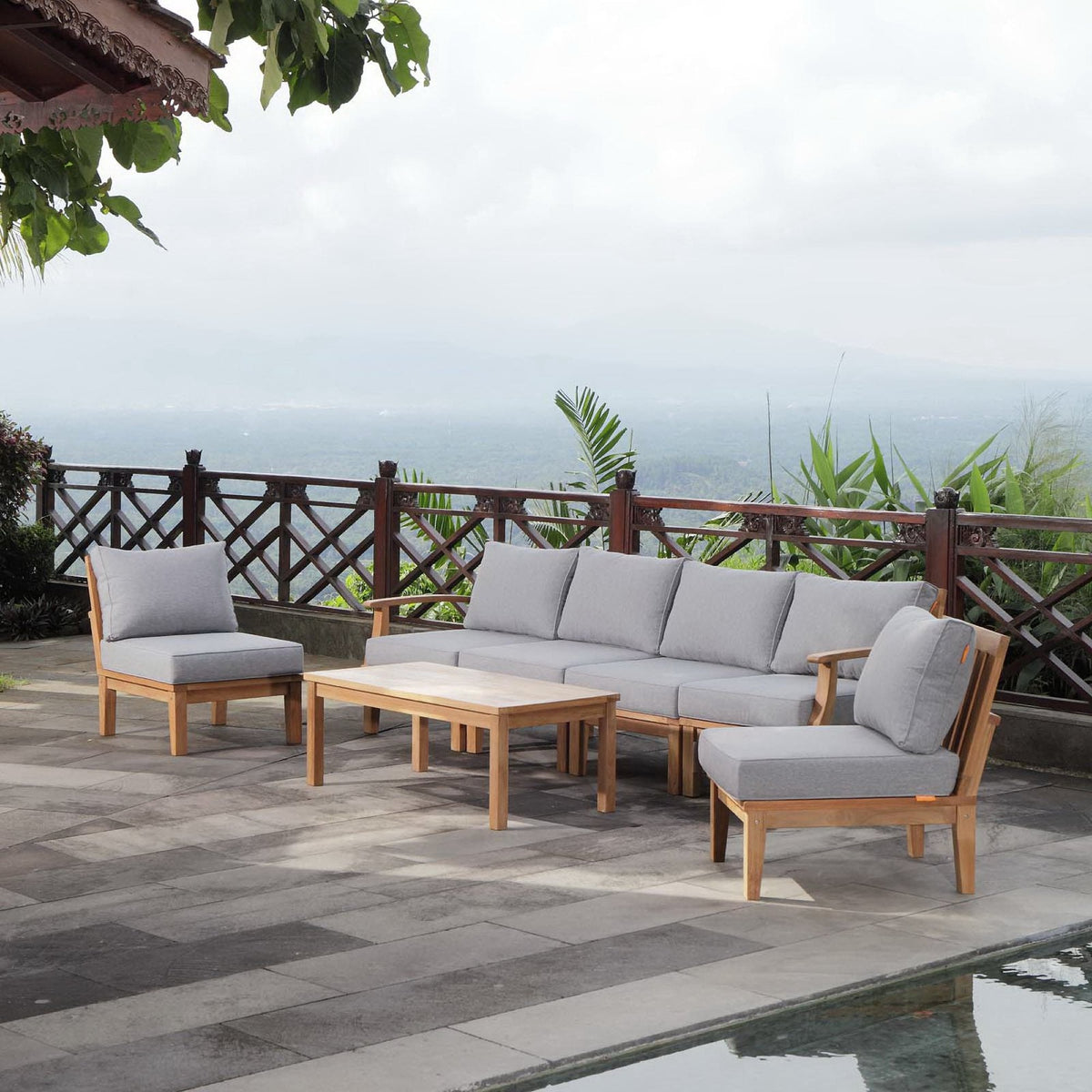 Marina 7-piece outdoor teak sofa set with light gray cushions and two coffee tables on deck on Tampa Home & Garden Store