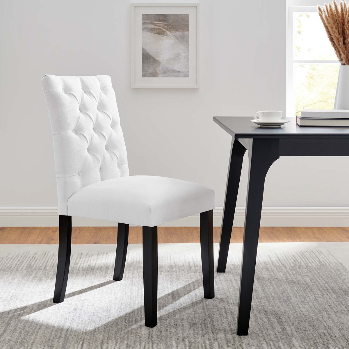 Duchess Button Tufted Fabric Dining Chair white fabric with dark legs beside a black table on Tampa Home & Garden Store