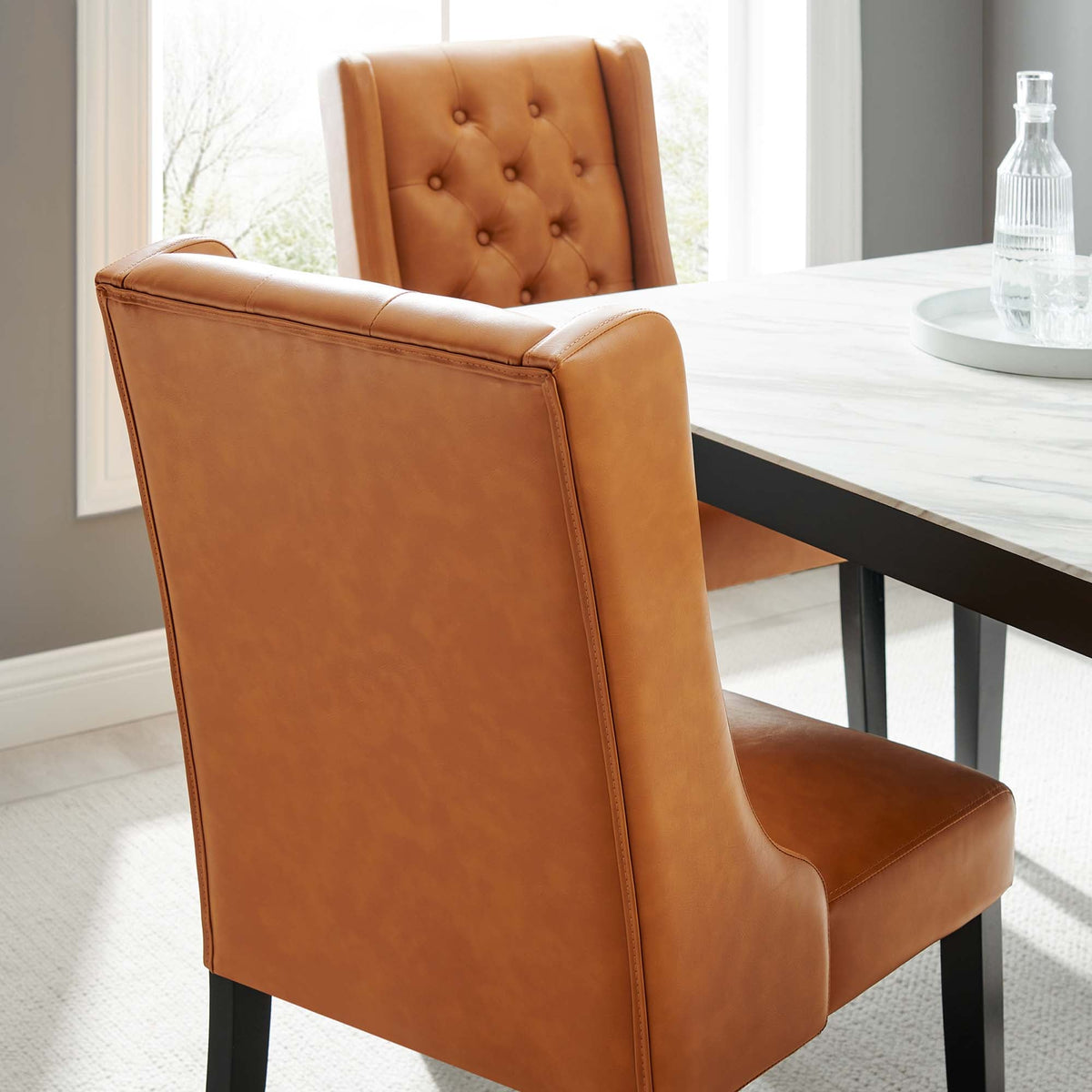 Baronet button tufted vegan leather dining chair in tan with black legs at marble table on Tampa Home & Garden Store